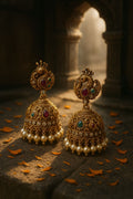 Ornate gold earrings with pearls on a dark background